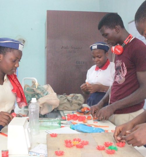 An artist Bassey teaching the members of Waste Rescue Club how to create functioning items from plastic trash Photo: Solomon Eko